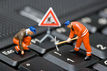 Image showing Miniature figures working on a computer keyboard.