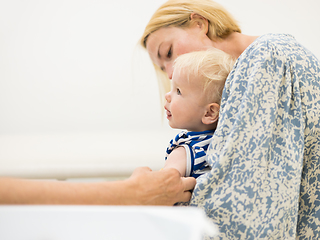 Image showing Child beeing vaccinated by pediatrician in presence of his mother. Preventive vaccination against Diphtheria, whooping cough, tetanus, hepatitis, haemophilus influenzae, pneumococcus, poliomyelitis