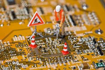 Image showing Miniature figures working on a circuit board.