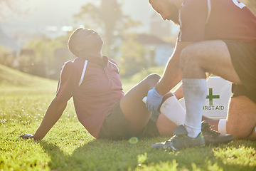 Image showing Football, medic and man with injury, field and pain with bruise, broken and inflammation with sunshine. Person, player and medical professional with equipment, fitness and match with emergency