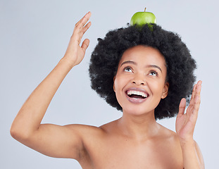 Image showing Apple, balance and black woman with health, organic and diet for wellness and healthy in studio. Excited, smile and happy model with green fruit, skin nutrition and vegan food with grey background