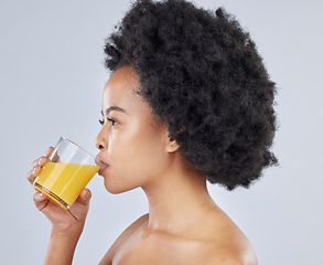 Image showing Woman, glass and orange juice in studio for beauty of vitamin c benefits on gray background. Face, african model and drink citrus fruit smoothie for healthy skin, weight loss diet and detox nutrition