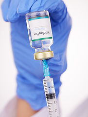 Image showing Doctor, hands and syringe with monkeypox vaccine for cure, flu shot or vaccination at hospital. Closeup of medical person or healthcare worker extracting vial or antibiotic with needle for injection