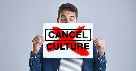 Image showing Cancel culture, person and protest sign in hand with message for social media violence and support in studio. Banner, man and face with mockup space for solidarity and opinion on grey background