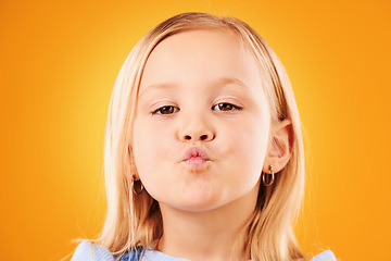 Image showing Portrait, kiss and girl child in studio with love, expression or gesture against an orange background space. Faces, kisses and kid with emoji facial expression for fun, personality or cute affection