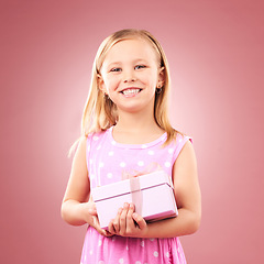 Image showing Child, gift or present portrait in studio for birthday, holiday or happy celebration. Excited girl kid on a pink background with box for surprise, giveaway prize or celebrate win with smile