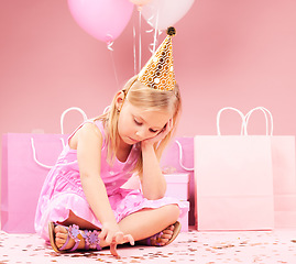 Image showing Depression, sad birthday and child on pink background disappointed for party, celebration and event. Lonely, emotion and unhappy, lonely and upset girl with balloons, presents and gifts in studio