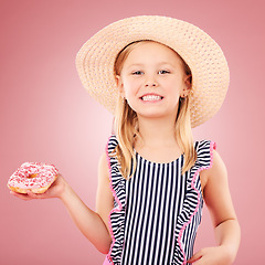 Image showing Happy, portrait and girl with a donut or child with sugar, dessert and sweet craving on pink background in studio. Face, smile and hungry kid with donuts on holiday, vacation or weekend diet