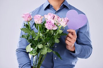 Image showing Flowers, man and heart in studio for love on grey background, roses and gift for thank you or present. Bouquet, person and purple paper frame, care and support for valentines day, date or offer