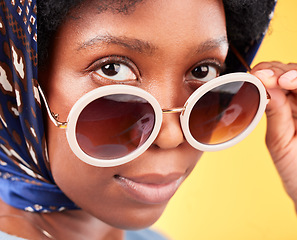 Image showing Fashion, retro and sunglasses with portrait of black woman in studio for vintage, trendy and beauty. Elegant, vision and serious with face of person and scarf on yellow background for frames or style