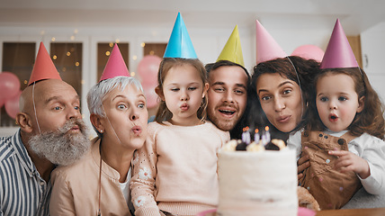 Image showing Happy birthday, gift and big family blowing candles with cake in a home party, event and celebration together. Mother, father and grandparents excited for surprise gathering with children or kids