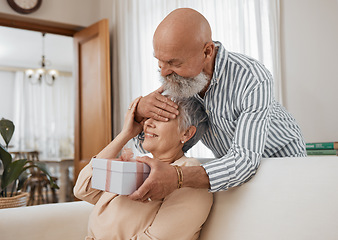 Image showing Senior couple, gift and sofa with eyes covered for surprise, anniversary or birthday in home living room. Elderly man, woman and present in box for celebration, marriage or party with love on couch