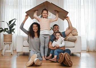 Image showing Parents, children and cardboard roof in portrait, smile or excited for security, real estate or fresh start in family home. Mother, dad and kids on floor, box and happy together for support in house