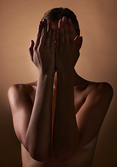 Image showing Woman, body and hands covering face on dark brown background in studio for creative aesthetic, art deco and skin texture. Shy person, model and hide in shadow for nude beauty, wellness and sensuality