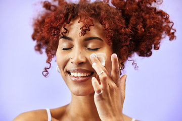 Image showing Wellness, skincare or happy woman with face lotion or sunscreen creme product in grooming routine. Dermatology cosmetics, purple background or beauty model with smile to apply facial cream in studio