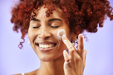 Image showing Beauty, skincare or happy woman with face lotion or sunscreen creme product in grooming routine. Dermatology cosmetics, purple background or biracial model with smile to apply facial cream in studio