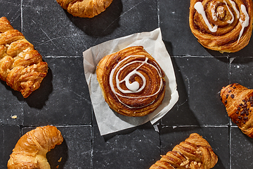 Image showing assorted pastries on dark grey old tiles background