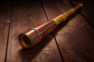 Image showing Vintage spyglass on wooden background