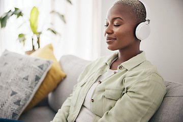 Image showing Black woman, listening and meditation podcast on headphones in home, living room or peace on sofa in lounge. Music, tech and happiness on face of person with calm, mindset and wellness in apartment