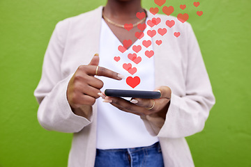 Image showing Phone, hands and woman with heart icon for online media, social network or feedback on mobile app. Smartphone, closeup and user typing post, communication and love sign emoji on green background wall