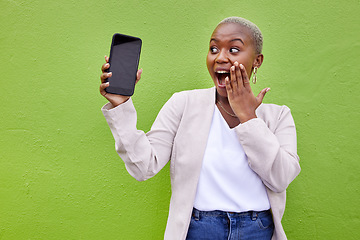 Image showing Surprise, woman and phone screen with mockup by a wall or green background with wow advertising. Shocked African person or winner with a smartphone for social media, mobile app chat or website space