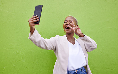 Image showing Woman, selfie and peace or hand sign by a wall or green background with social media. Excited african person with a profile picture, memory and influencer post or vlog with happy emoji outdoor