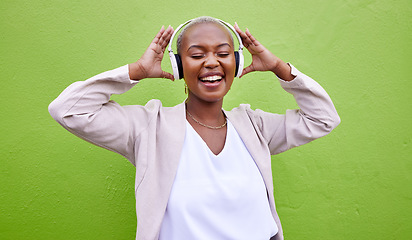 Image showing Music, headphones and happy black woman dance on green wall background mockup space. Radio, singing and African person streaming podcast, hearing audio or listening to sound of jazz media for freedom