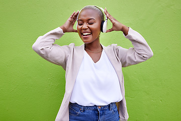 Image showing Music, headphones and black woman dance on green wall background mockup space. Radio, singing and happy African person streaming podcast, hearing audio or listening to sound of jazz media for freedom