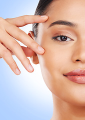 Image showing Half face, closeup or woman with skincare, cosmetics or dermatology on a blue studio background. Portrait, person or model with beauty, luxury or wellness with self care, shine or glow with treatment