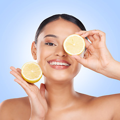 Image showing Woman, face and lemon with natural beauty, skincare and vitamin c cosmetic product isolated on blue background. Model in portrait with facial, fruit and dermatology, skin glow and citrus in studio