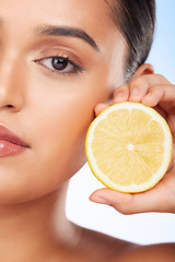 Image showing Beauty, portrait and studio woman with lemon for organic anti aging treatment, skincare detox or aesthetic cosmetics. Vitamin C benefits, spa wellness or half face of closeup model on blue background