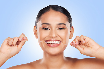 Image showing Woman, face and teeth whitening, flossing and dental, health and wellness isolated on blue background. Tooth cleaning process, oral care and product, fresh breath and veneers in portrait in a studio