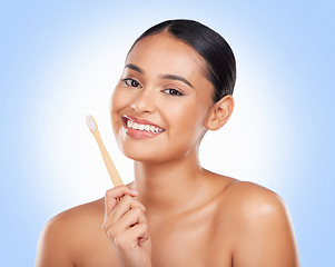 Image showing Happy portrait, woman and brushing teeth in studio for dental care, gingivitis and sustainable cosmetics on blue background. Model with bamboo toothbrush cleaning mouth, oral hygiene or healthy smile