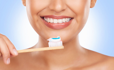 Image showing Brushing teeth, toothpaste and dental, woman and health with wellness isolated on blue background. Closeup, mouth and bamboo toothbrush, oral care and orthodontics with hygiene and grooming in studio