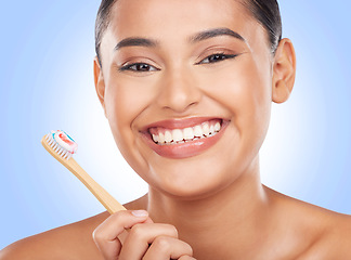 Image showing Happy portrait, woman and toothbrush on blue background for dental cleaning, gingivitis and beauty in studio. Model, toothpaste and brushing teeth with bamboo for oral hygiene, healthy smile and care