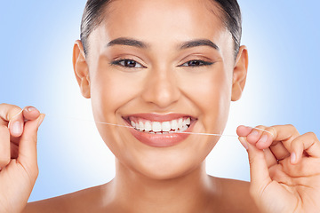 Image showing Woman, portrait and floss teeth in studio for healthy dental care, gingivitis and plaque on blue background. Face, happy model and oral thread for cleaning mouth, tooth or fresh breath of gum hygiene