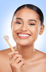 Image showing Happy woman, portrait and toothbrush in studio for dental cleaning, gingivitis or gums on blue background. Face of model, toothpaste and brushing teeth with bamboo for oral hygiene, healthy and smile