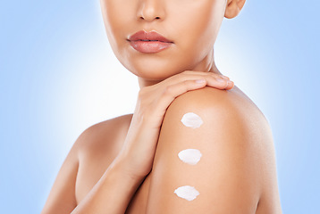 Image showing Body skincare, cream and studio person with skin cosmetics, anti aging glow and closeup hydration creme. Lotion application, sunscreen and shoulder of beauty model with moisturizer on blue background