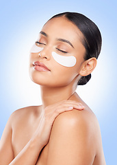 Image showing Skincare, beauty and woman with collagen pads for anti aging or skin glow on blue background. Cosmetics, facial detox and face of model with luxury mask or eye product for dermatology pads in studio.