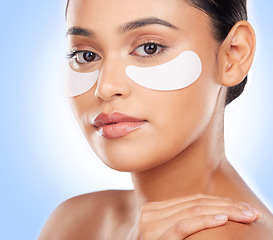 Image showing Skincare, portrait and woman with eye patch for anti aging luxury skin glow on blue background. Cosmetics, facial detox and face of model with solution or collagen product for dermatology in studio.