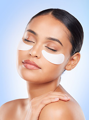 Image showing Skincare, beauty and woman with eye patch for anti aging or skin glow on blue background. Cosmetics, facial detox and face of model with luxury mask or collagen product for dermatology pad in studio.