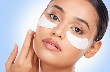 Image showing Portrait, beauty and eye mask with a natural woman in studio on a blue background for antiaging treatment. Face, skincare and wellness product with a young model at the salon for a facial application