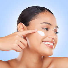 Image showing Face makeup, cream and happy woman with beauty cosmetics glow, self care wellness routine and facial hydration product. Skin treatment, happiness and studio model with sunscreen on blue background