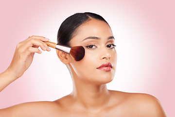 Image showing Cosmetics, makeup brush and portrait of woman in studio for glamour, glow or face routine. Beauty, self care and young Indian female model with facial cosmetology product isolated by pink background.