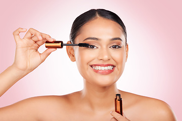 Image showing Portrait, smile and a woman with mascara on a pink background for eyelash beauty in studio. Smile, young and a female model marketing a cosmetics product for facial glow, skincare or wellness