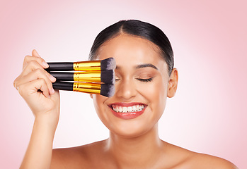Image showing Face makeup, beauty brush and happy woman with cosmetics tools, skincare wellness and facial transformation. Foundation application product, eyes closed and aesthetic studio person on pink background
