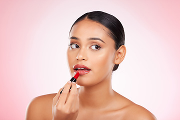 Image showing Red, lipstick and face of woman with makeup or cosmetics on pink background space and thinking about product. Lips, beauty and model with ideas for aesthetic skincare or choice of color on mouth