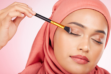 Image showing Makeup, brush and muslim woman in studio with eyeshadow, application and wellness on pink background. Beauty, glamour and female model with hijab, cosmetics and luxury, makeover or transformation