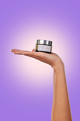 Image showing Hand, cream or serum with beauty and skincare, advertising product with dermatology isolated on purple background. Person with cosmetics for skin and promotion, container and facial mask in studio