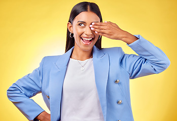 Image showing Fashion, smile and vision with a business indian woman on a yellow background in studio for work style. Hand, eye and a happy young professional person thinking of an idea for her corporate future